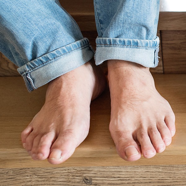 Jalat tummaa tammilattiaa vasten